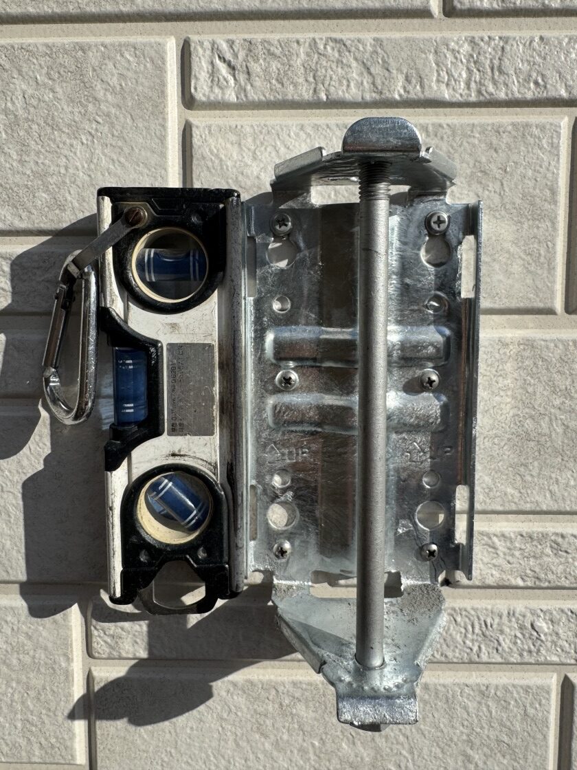 デザインアンテナ取付金具を水平器で確認しながら固定する様子