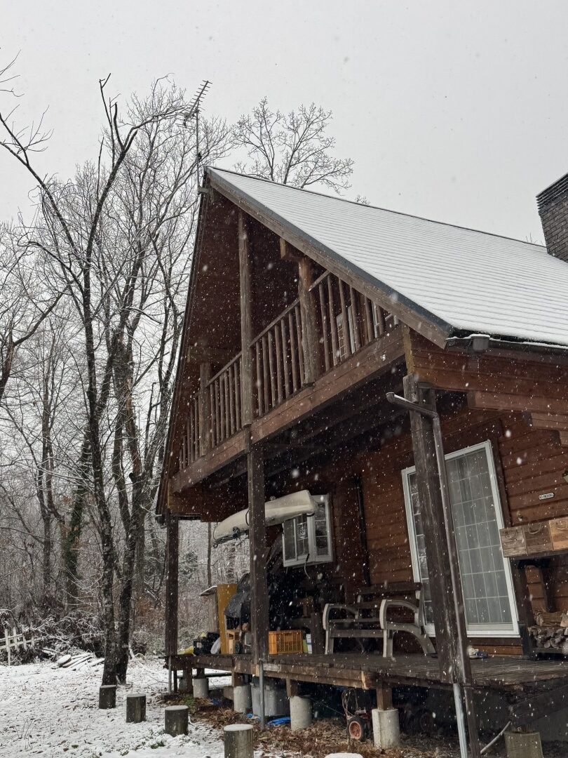 雪が降る中、屋根上に設置された施工前の既存アンテナ