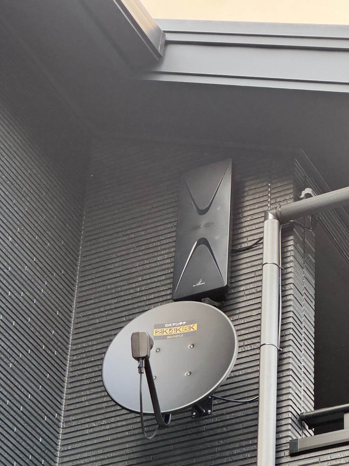 外壁に設置された黒のデザインアンテナ。