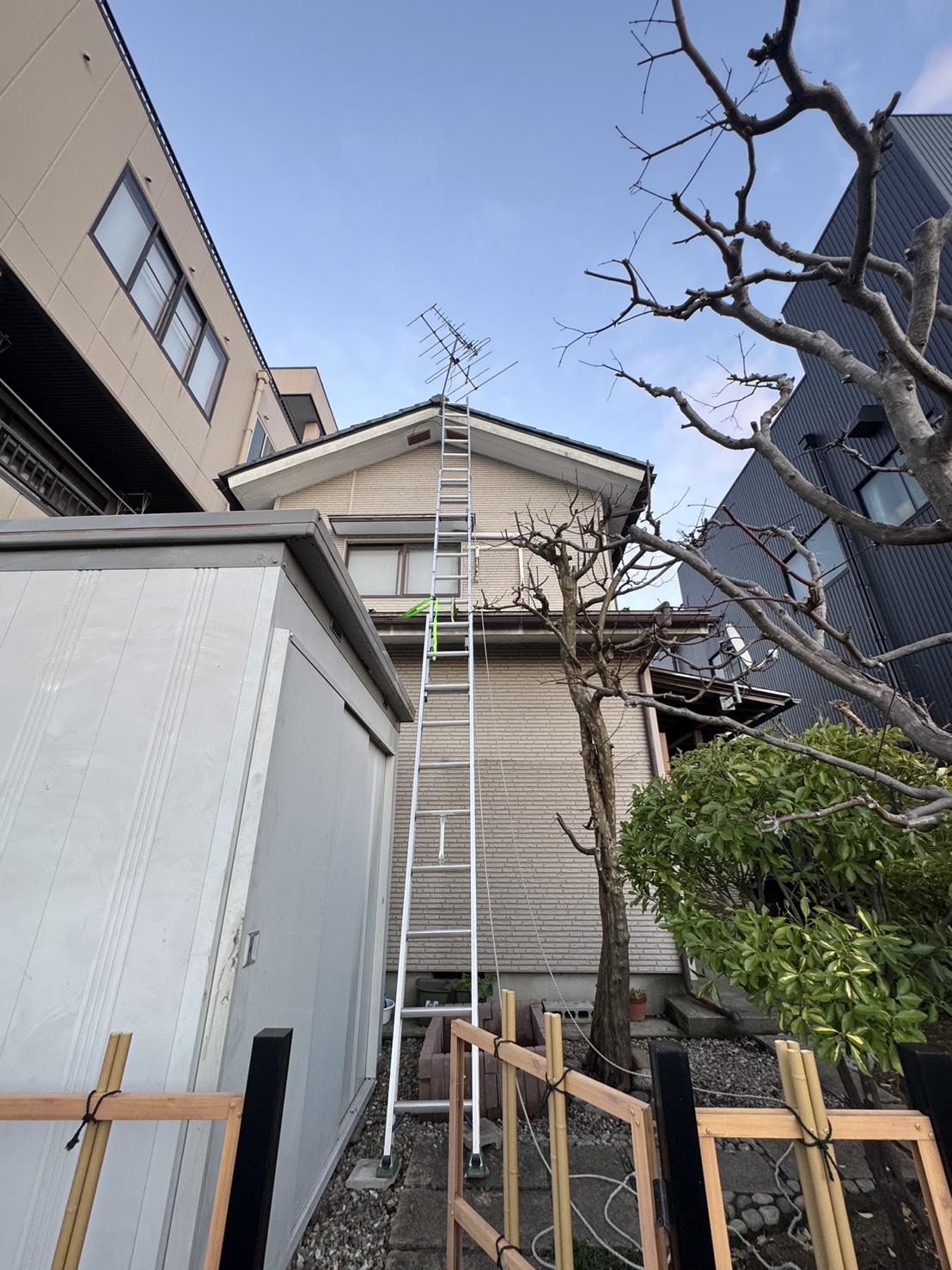 施工前：屋根上に設置された既存アンテナの状況（はしごを掛けて点検）