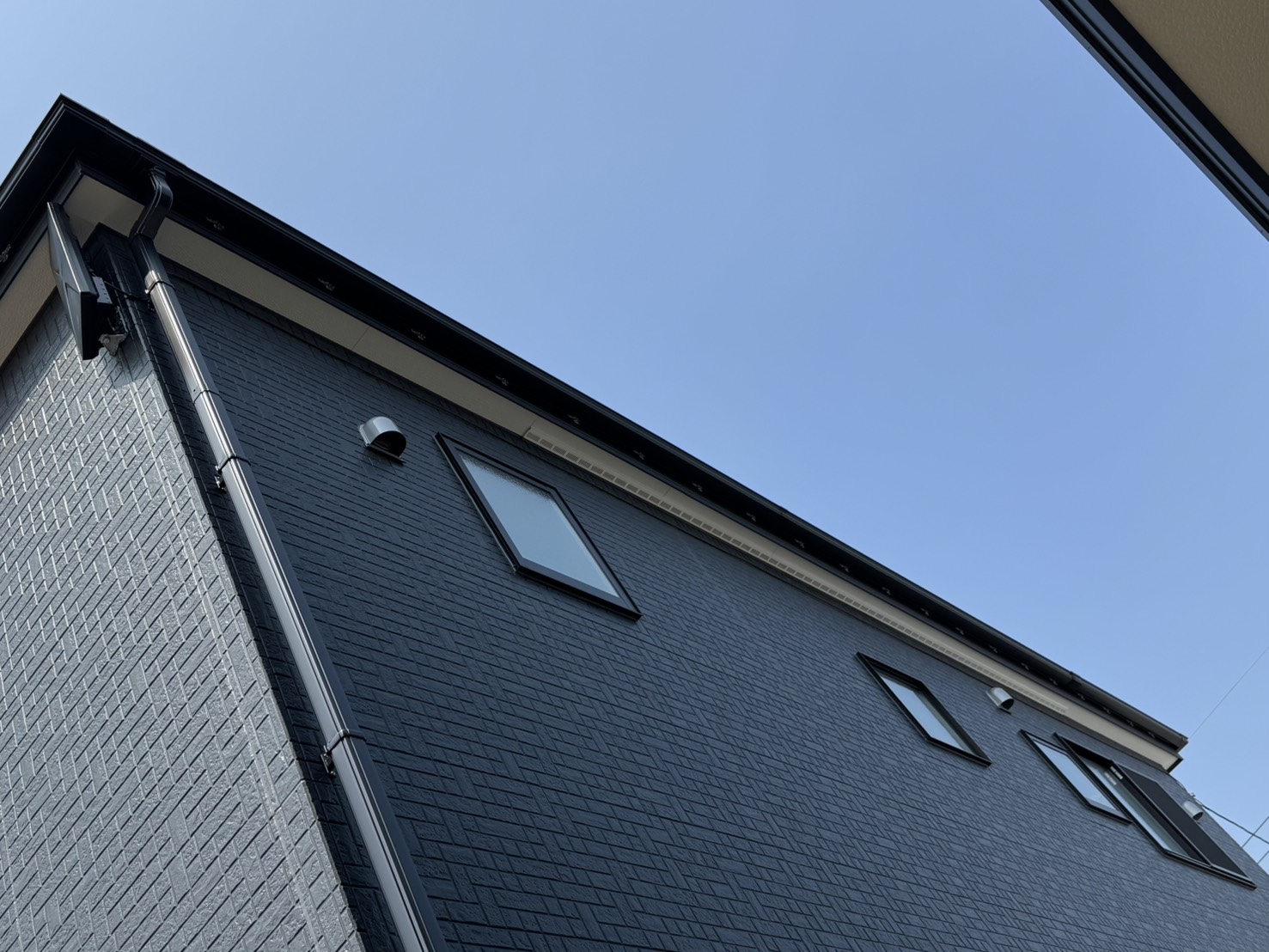 外壁に設置したブラックの平面アンテナと住宅外観