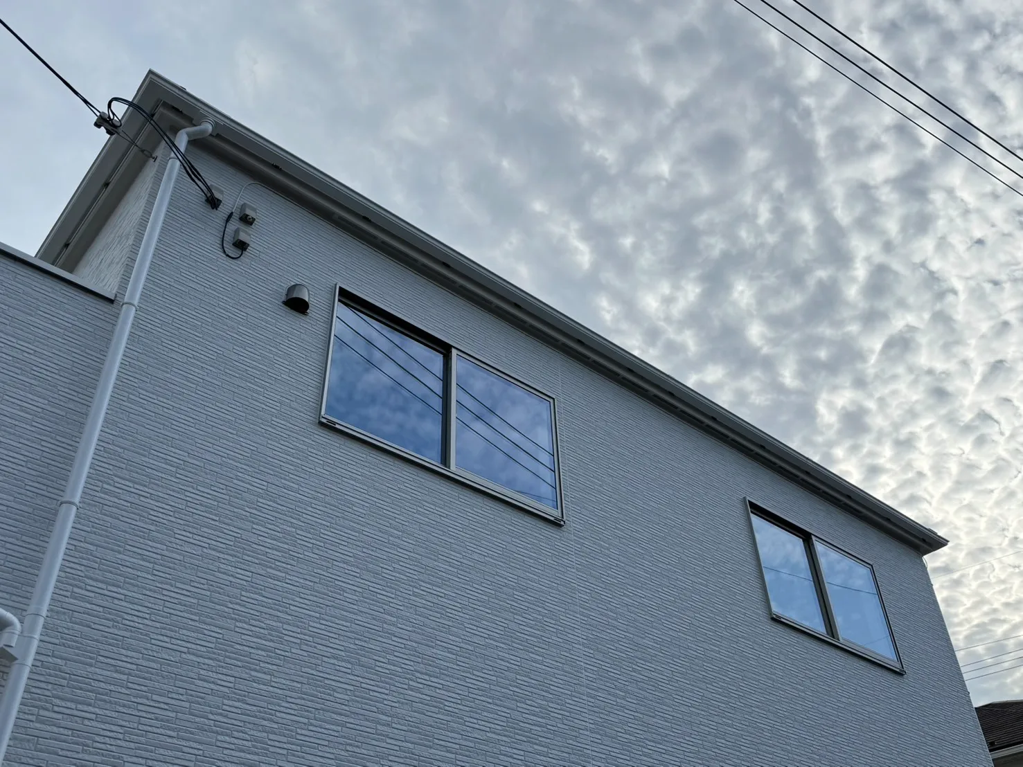 屋根のひさし下を通してアンテナ配線を延長している様子