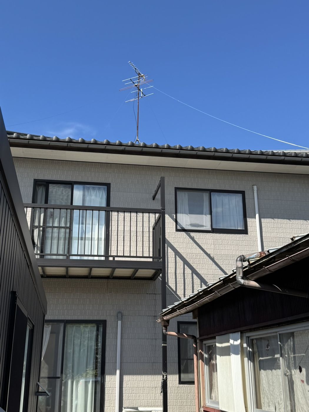 滋賀県草津市M様邸の施工前の外観と屋根上に残る旧アンテナ